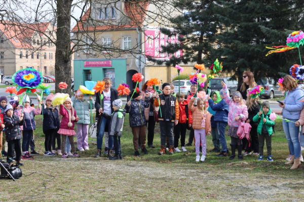 na zdjęciu grupka dzieci które trzymają w ręku kwiaty z bibuły