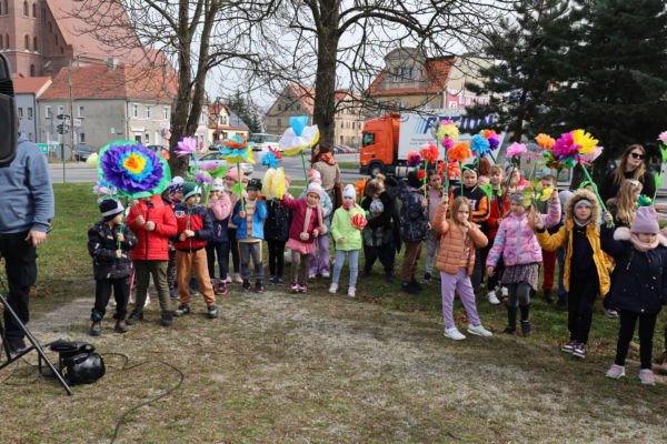 na zdjęciu grupka dzieci które trzymają w ręku kwiaty z bibuły