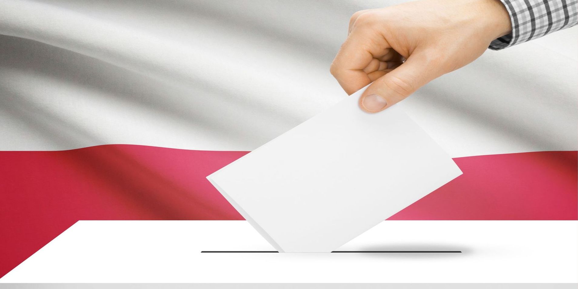 zdjęcie ręki która wrzuca kartę wyborczą do urny, tło Polska flaga
